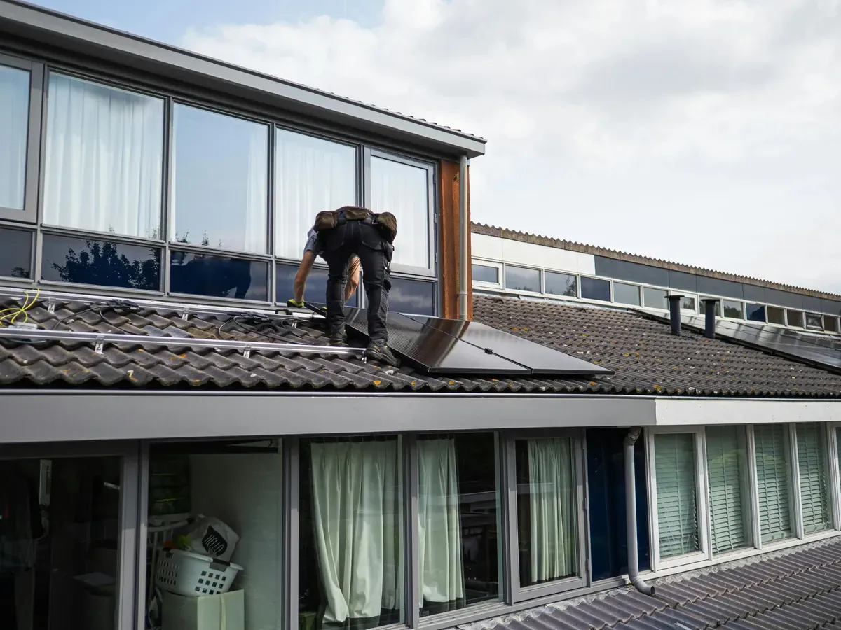 Installateur posant des panneaux solaires sur un toit